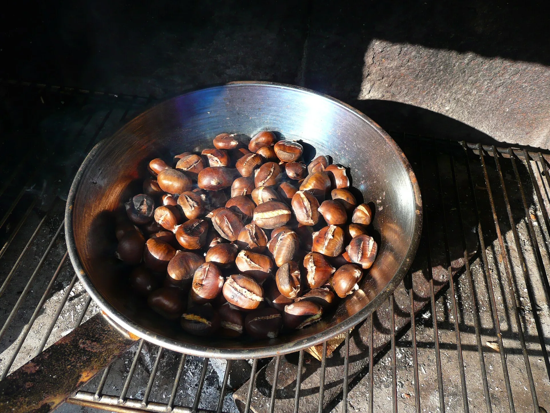Castagne arrostite in una padella forata sulla brace